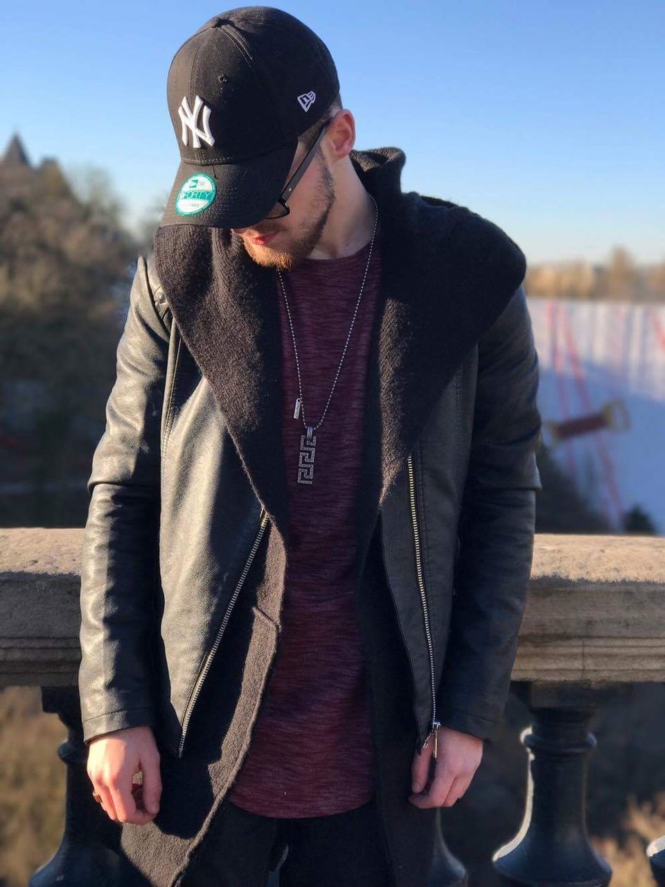 YOUNG MAN STANDING AGAINST SKY