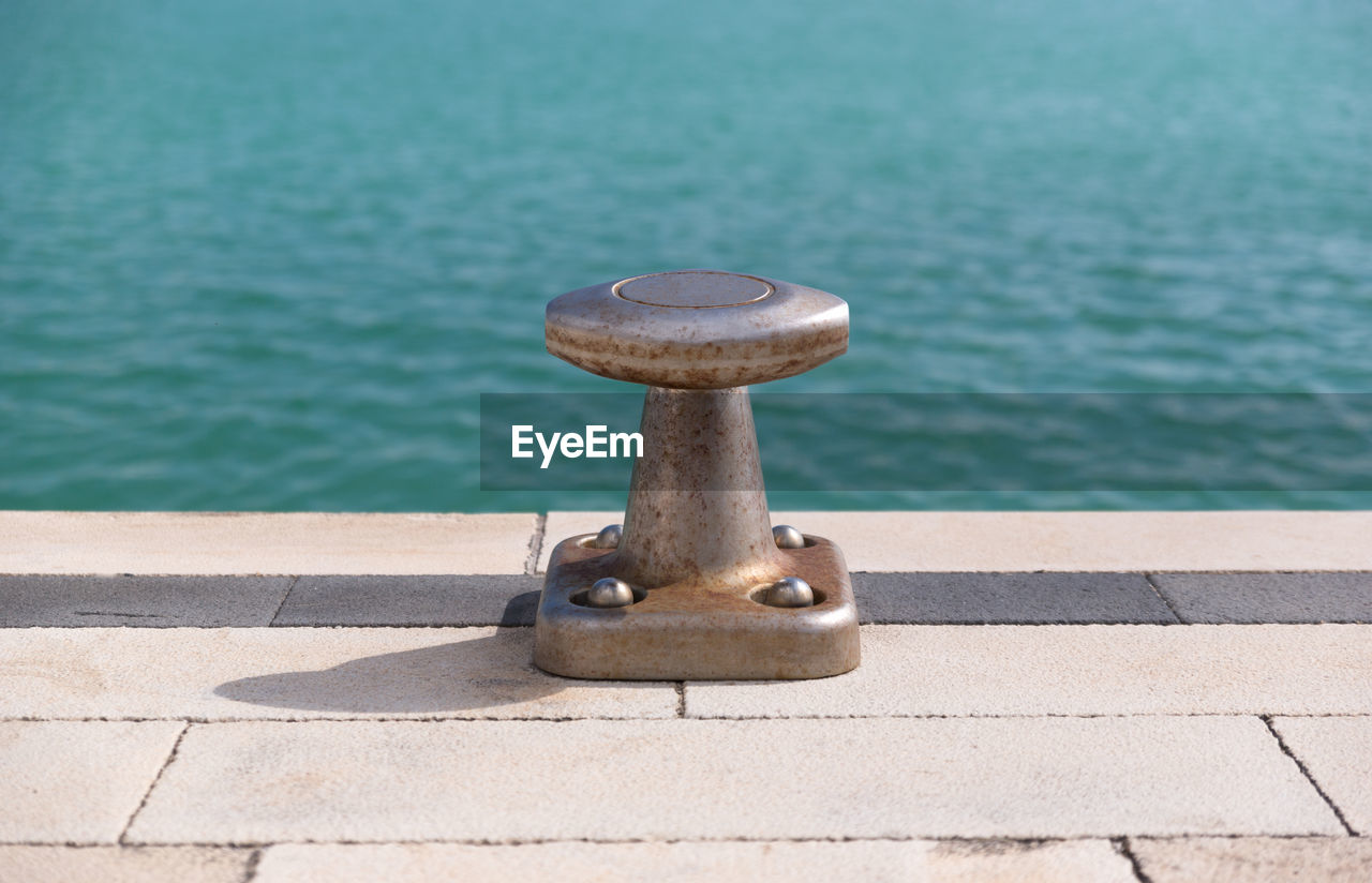 Close-up of metal bollard on pier