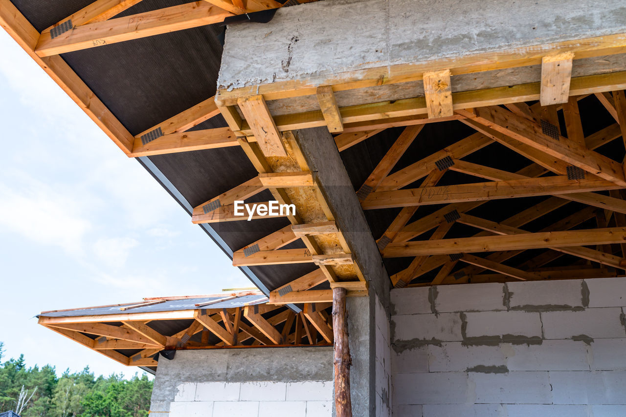 Roof trusses covered with a membrane on a detached house under construction, visible roof elements