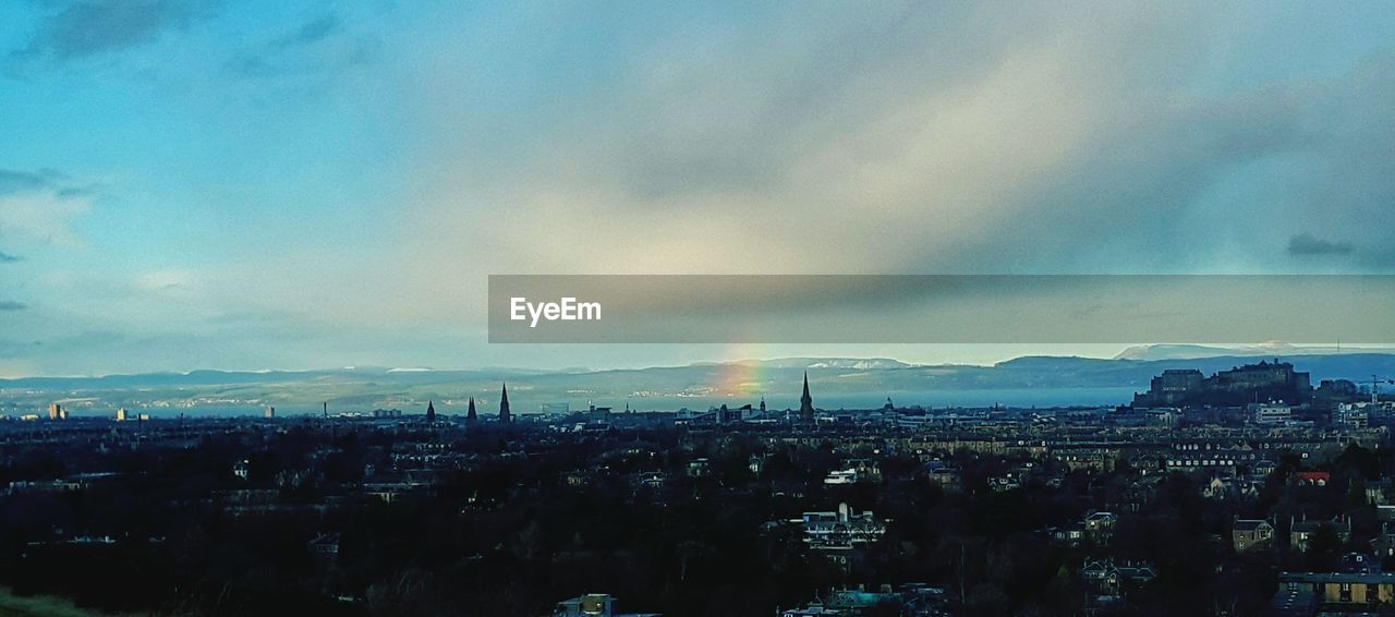 Cityscape against cloudy sky