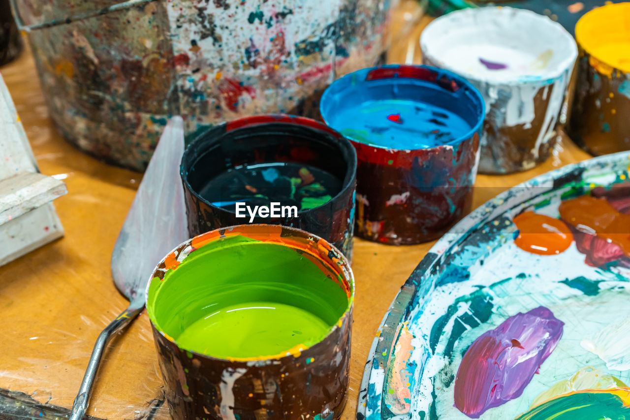 Jars of the artist with bright colors in the art workshop