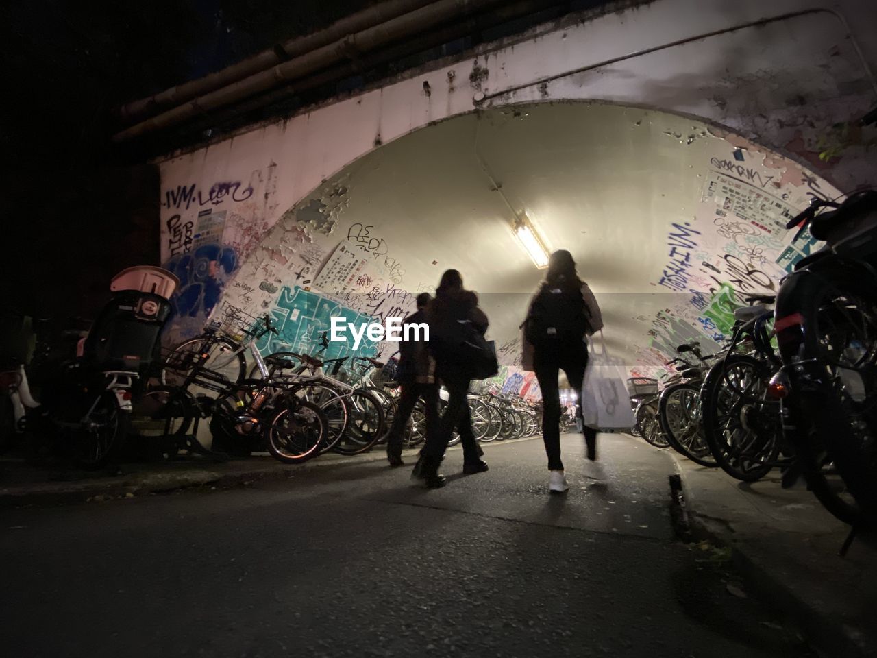 bicycle, night, darkness, transportation, architecture, city, full length, group of people, mode of transportation, adult, vehicle, men, graffiti, street, silhouette, built structure