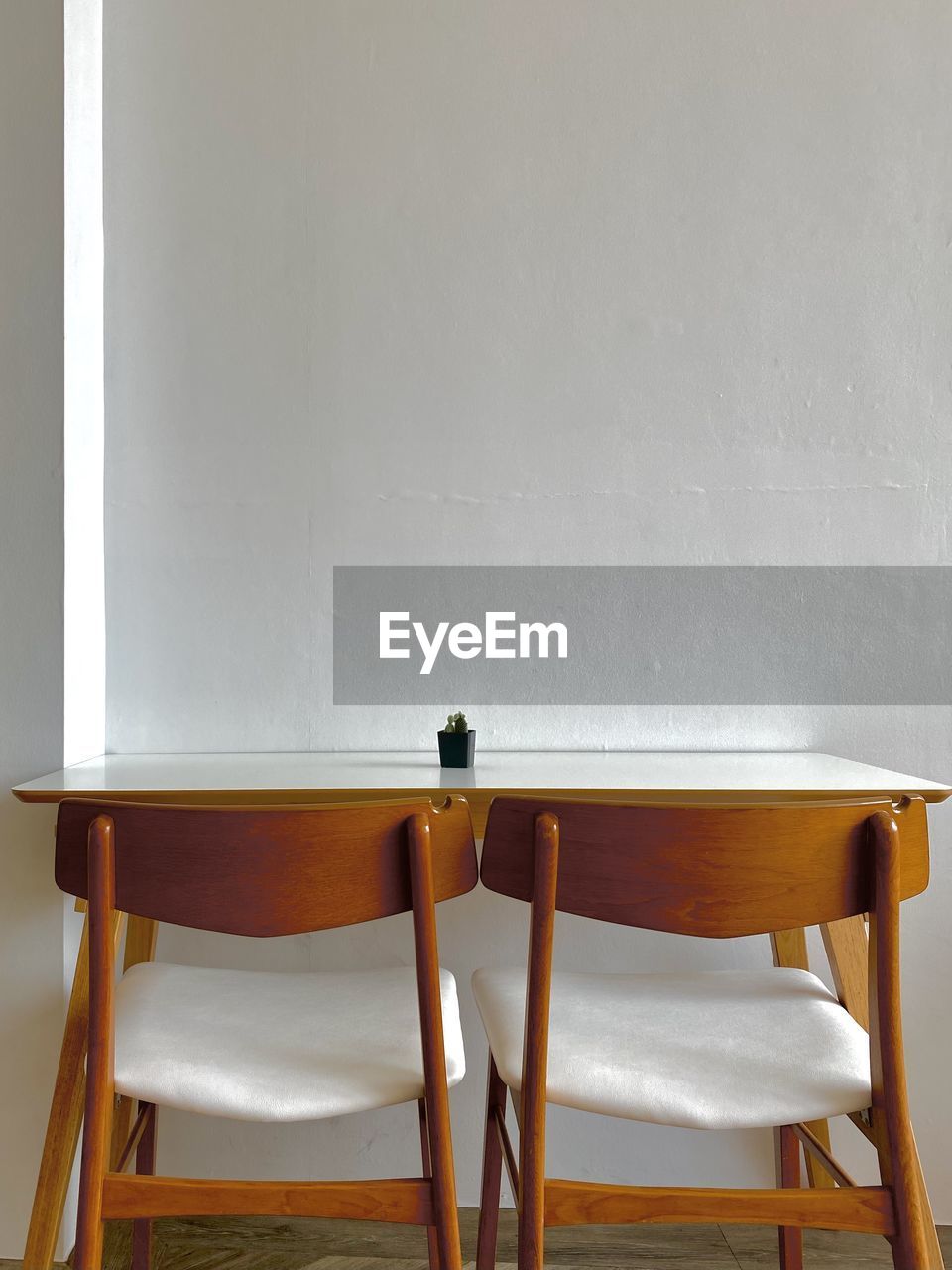 Empty chairs and table against wall at home