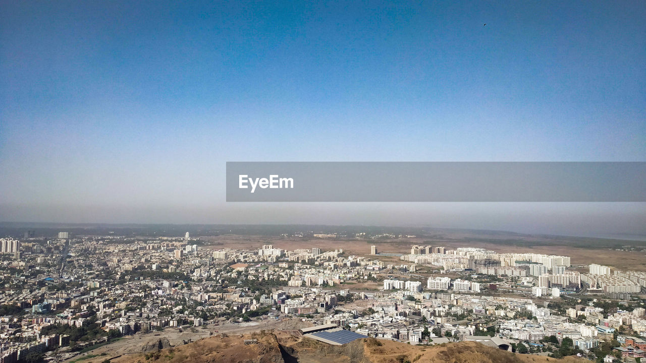 HIGH ANGLE VIEW OF TOWNSCAPE AGAINST CLEAR BLUE SKY