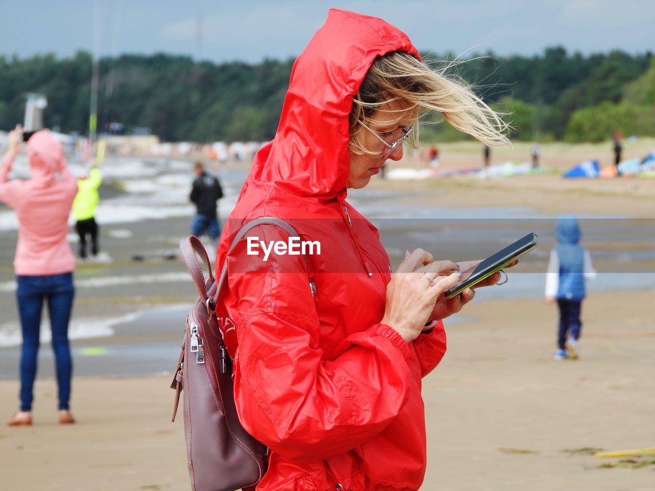 Midsection of woman holding mobile phone while standing on land