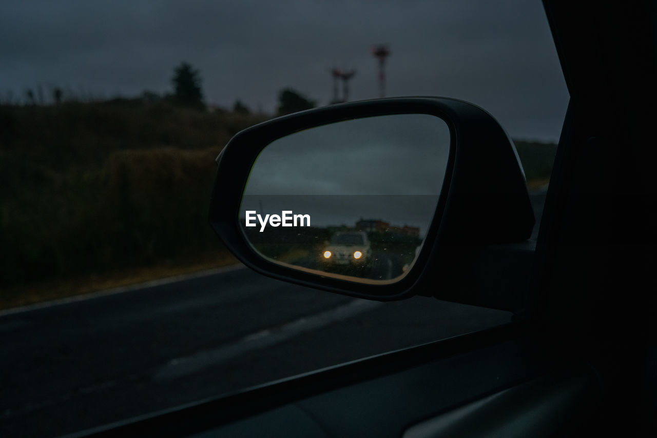 REFLECTION OF SIDE-VIEW MIRROR OF CAR ON ROAD