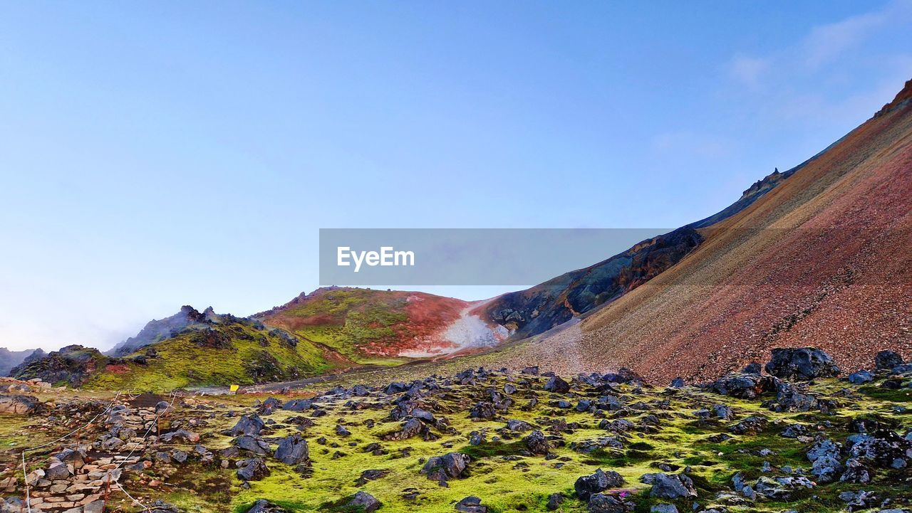 Amazing colorful view of volcanic mountains and lava field against clear sky