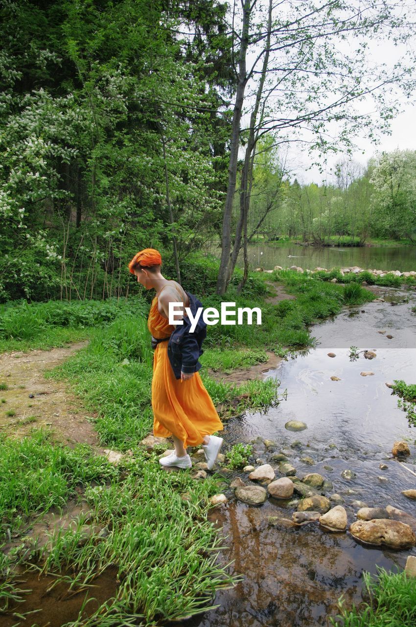 SIDE VIEW OF MAN WALKING ON RIVERBANK