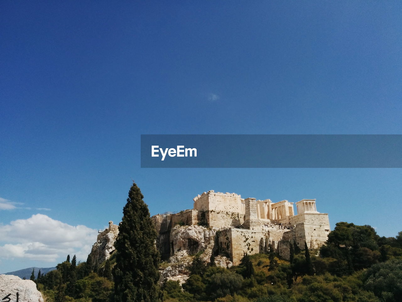 Low angle view of acropolis temple on hill against sky