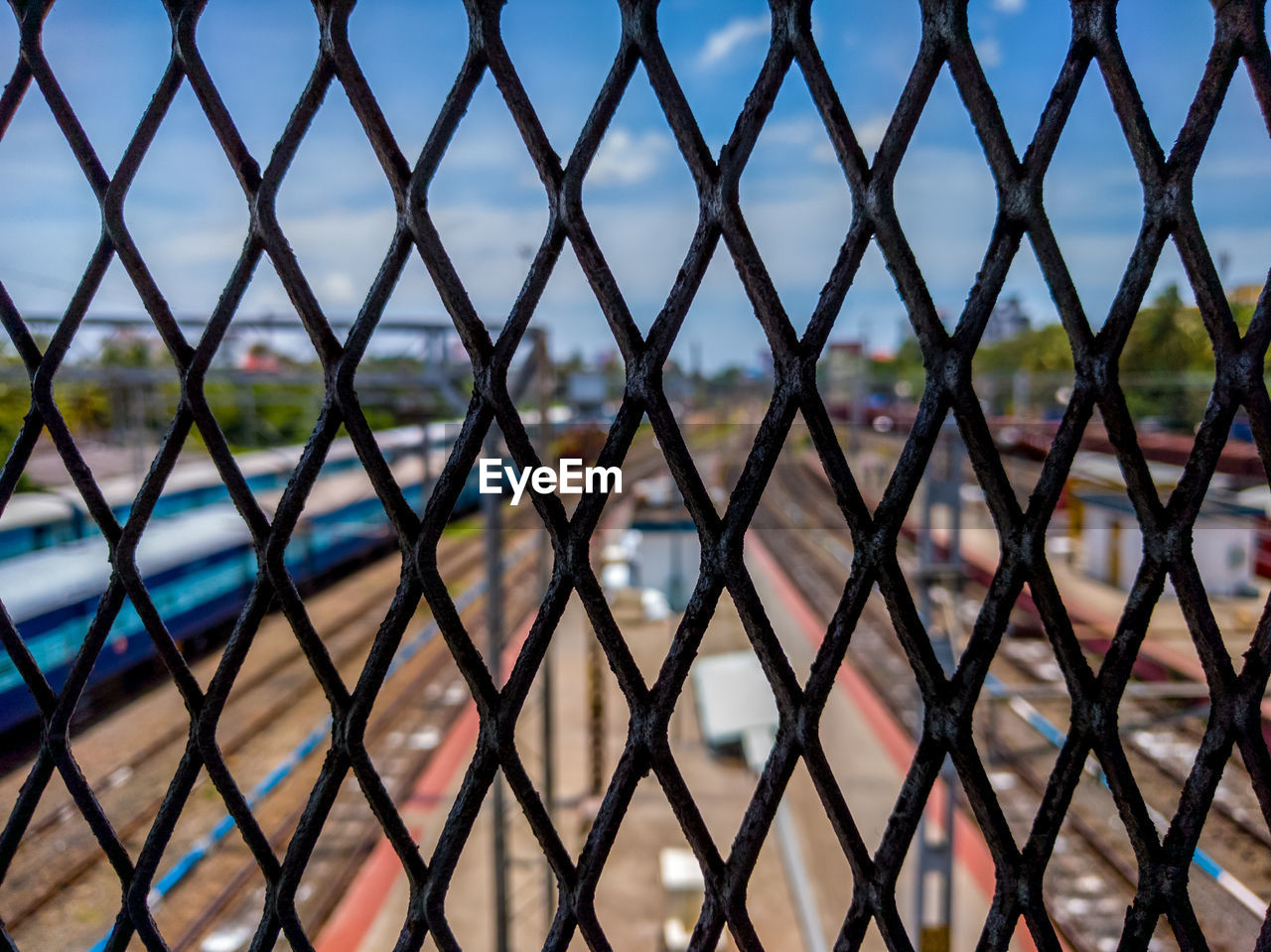Close-up of chainlink fence against railroad tracks
