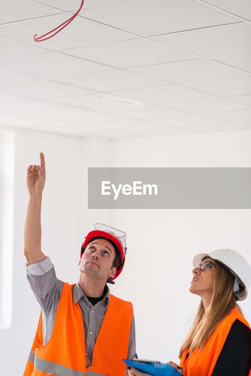 Architect showing ceiling to colleague