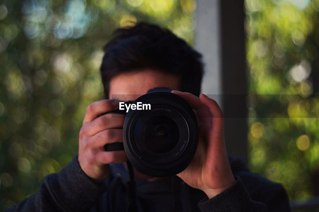 Close-up of man photographing through camera