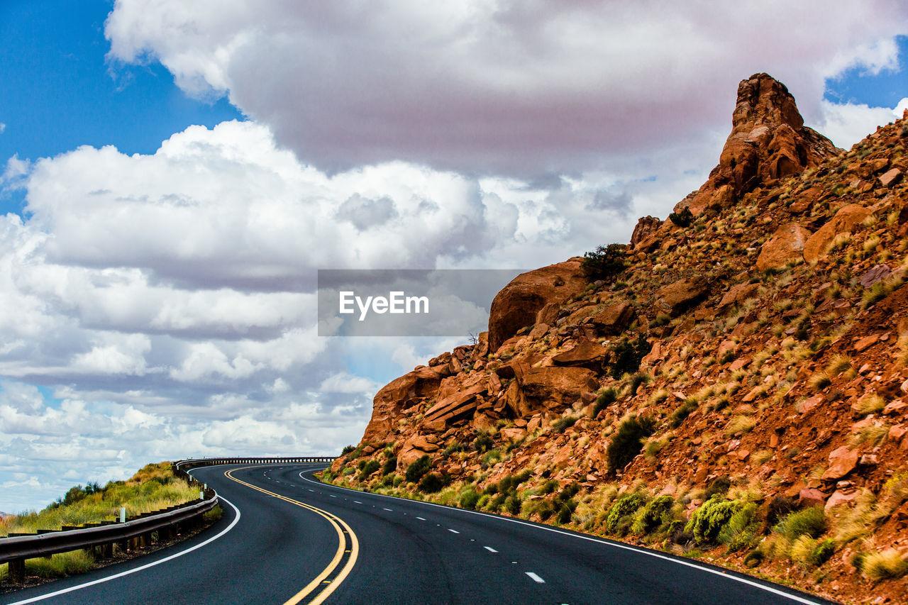 ROAD BY MOUNTAINS AGAINST SKY