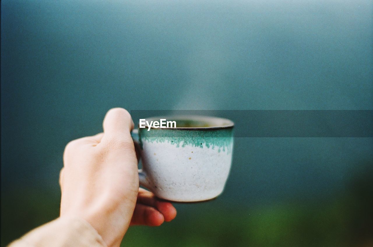 Close-up of hand holding coffee cup