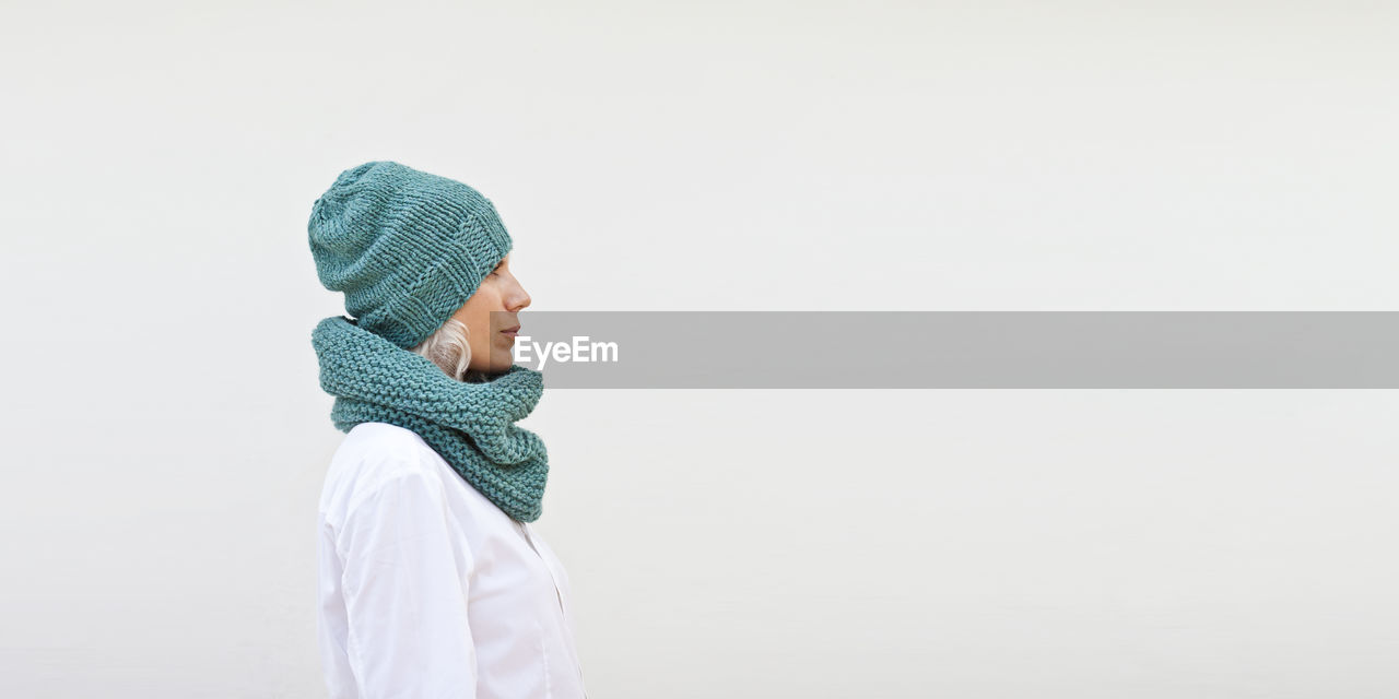 Side view of woman wearing hat against white background