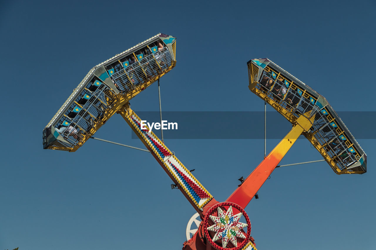 Low angle view of ferris wheel against clear sky