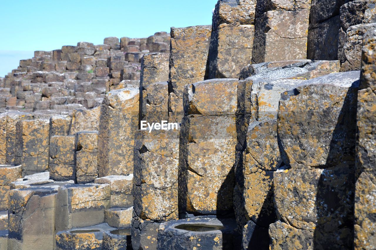 Rocky formations at giant causeway against clear sky