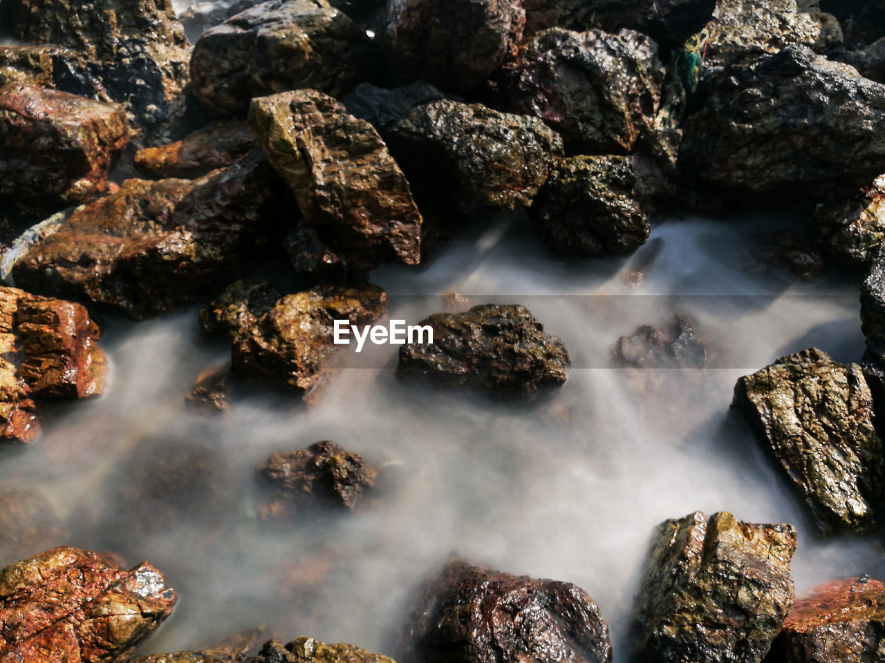 High angle view of stream by rocks