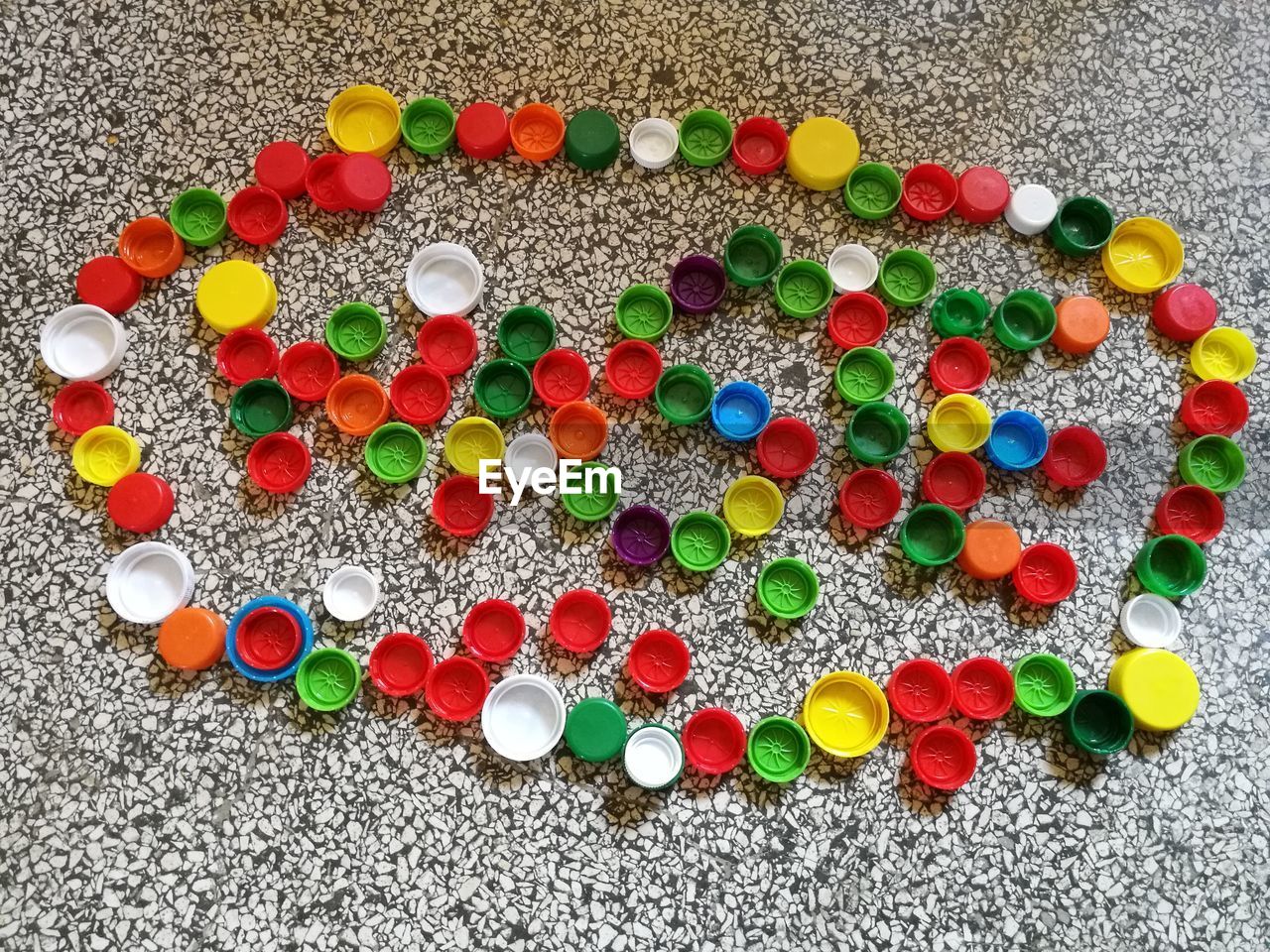 High angle view of multi colored bottle caps on floor