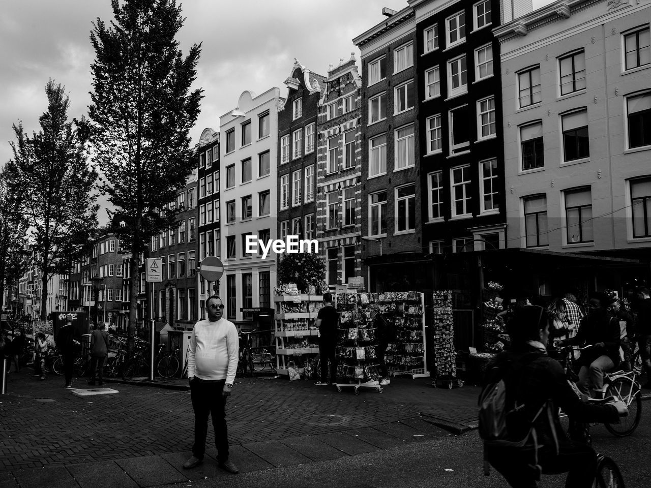 REAR VIEW OF PEOPLE WALKING ON STREET AGAINST BUILDINGS