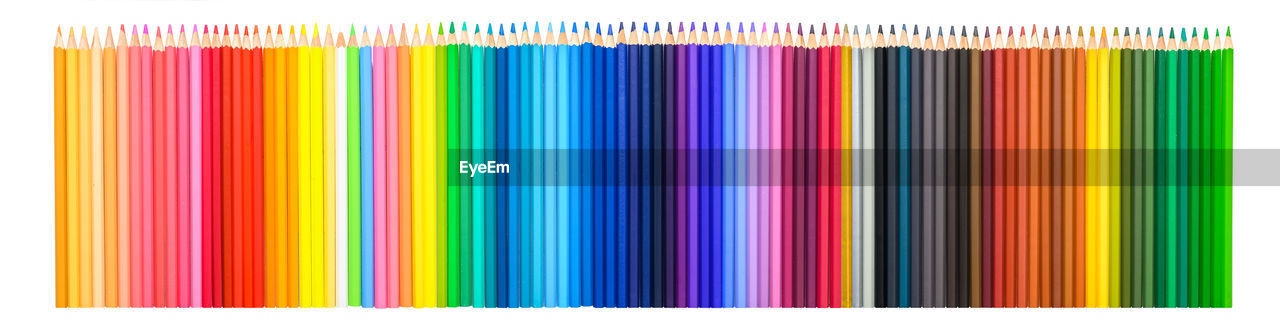 MULTI COLORED PENCILS AGAINST BLUE BACKGROUND