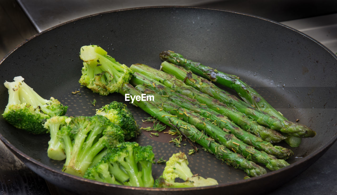 Close-up of broccoli and asparagus in pan