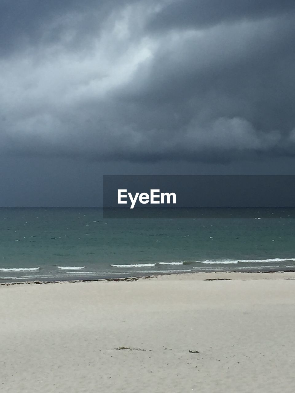 SCENIC VIEW OF BEACH AGAINST CLOUDY SKY