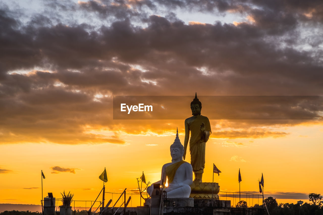 STATUE AGAINST ORANGE SKY