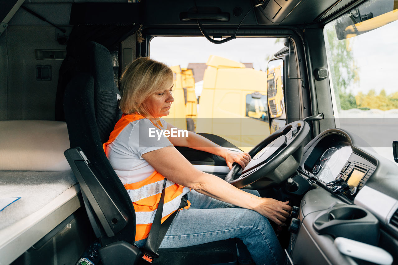 Side view of woman sitting in truck