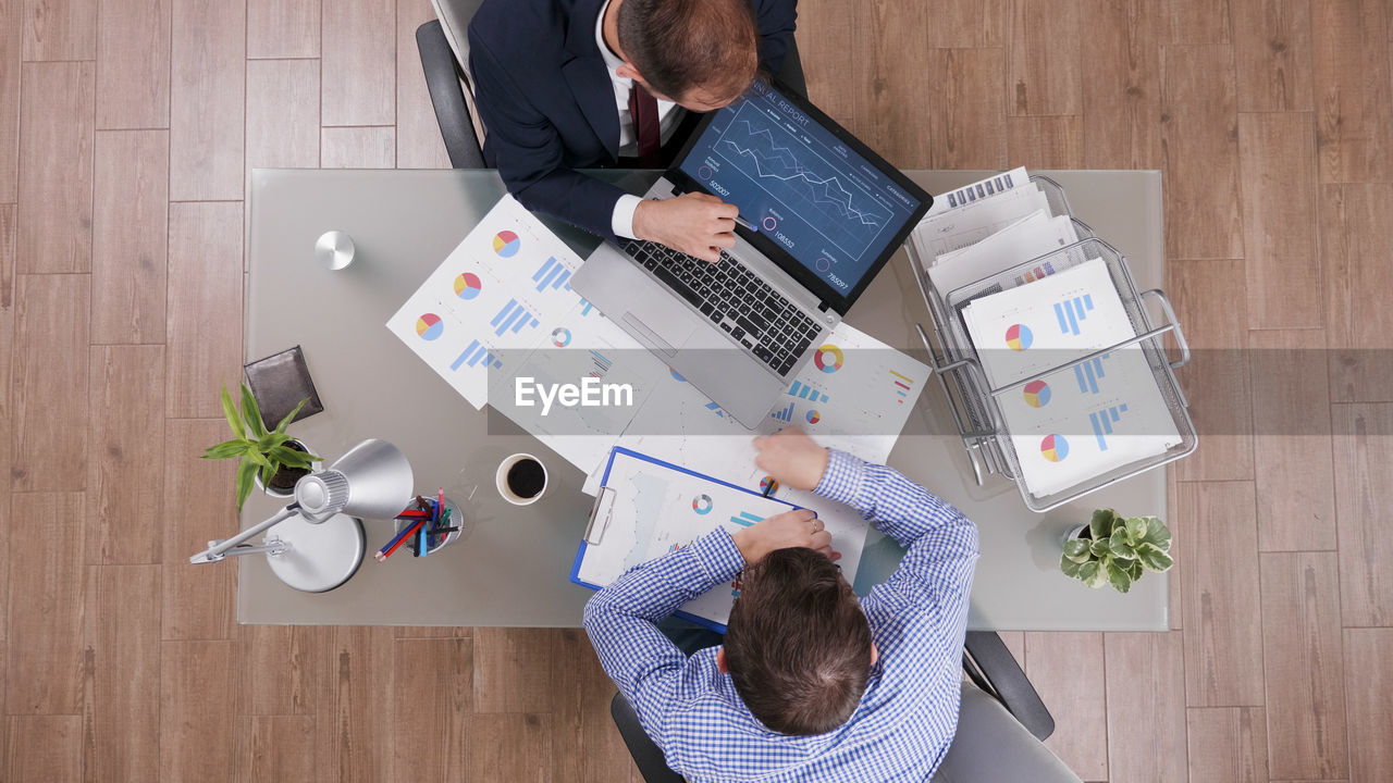 High angle view of people using laptop on table