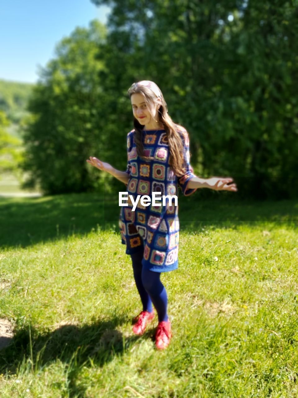 FULL LENGTH OF WOMAN STANDING ON GRASSY FIELD