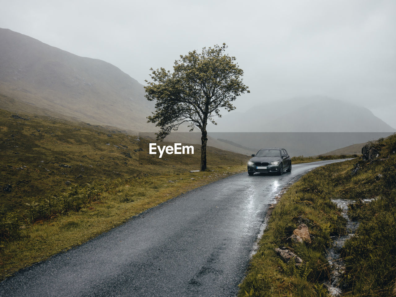 Car driving on road through glen etive