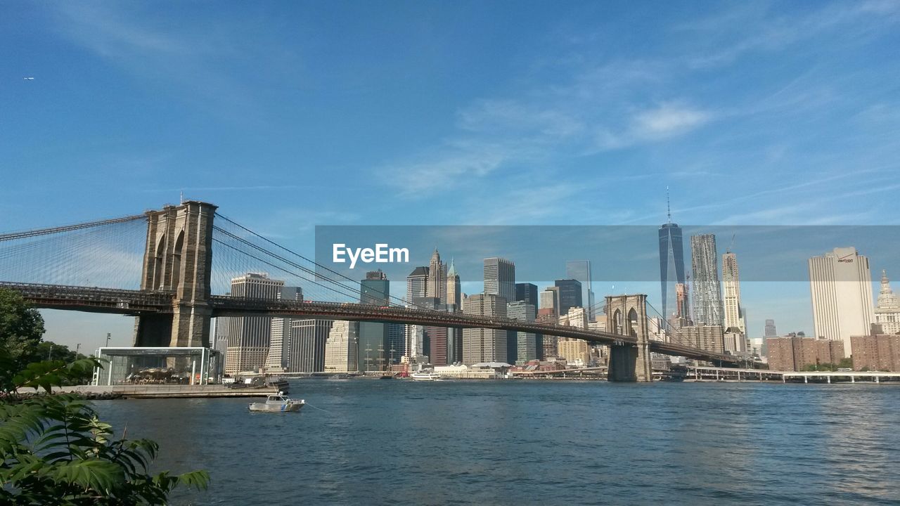 Brooklyn bridge over east river against modern buildings at manhattan