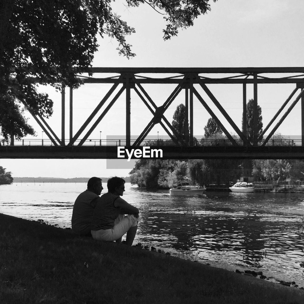 WOMAN SITTING ON BRIDGE