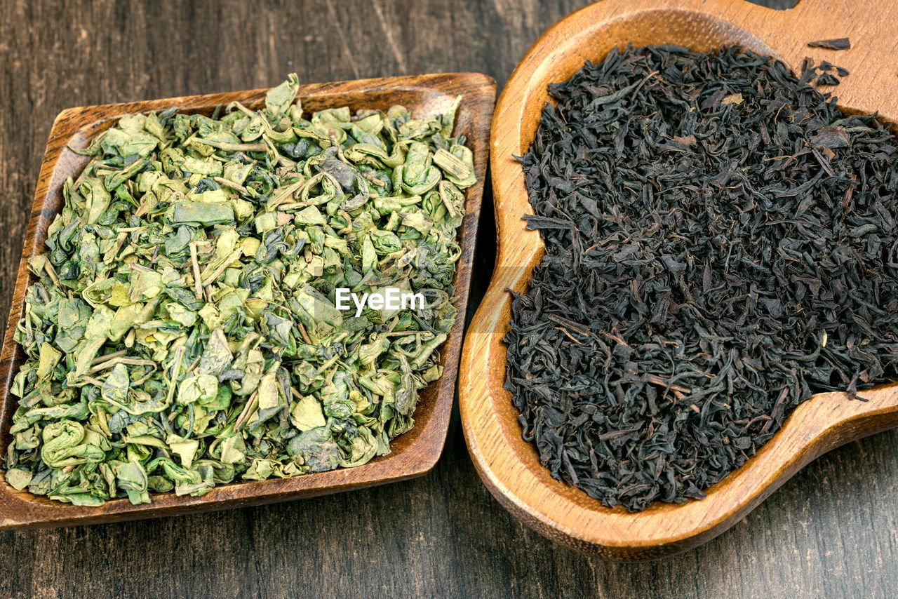 Close-up of dry herbal tea leaves in wooden bowls on table