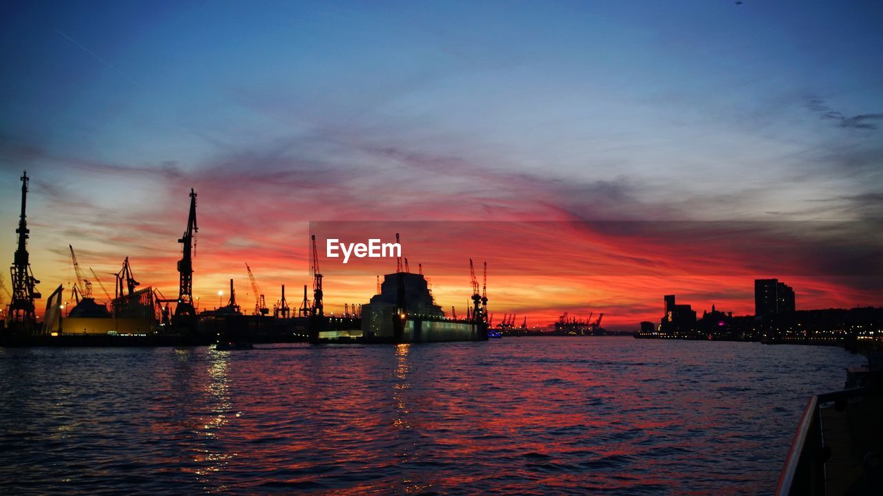 SCENIC VIEW OF HARBOR AGAINST SKY DURING SUNSET