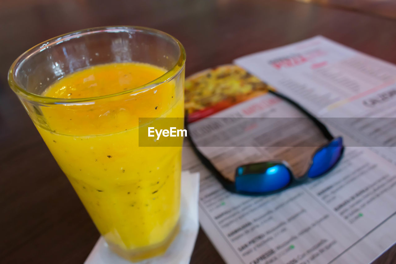 CLOSE-UP OF DRINK IN GLASS ON TABLE