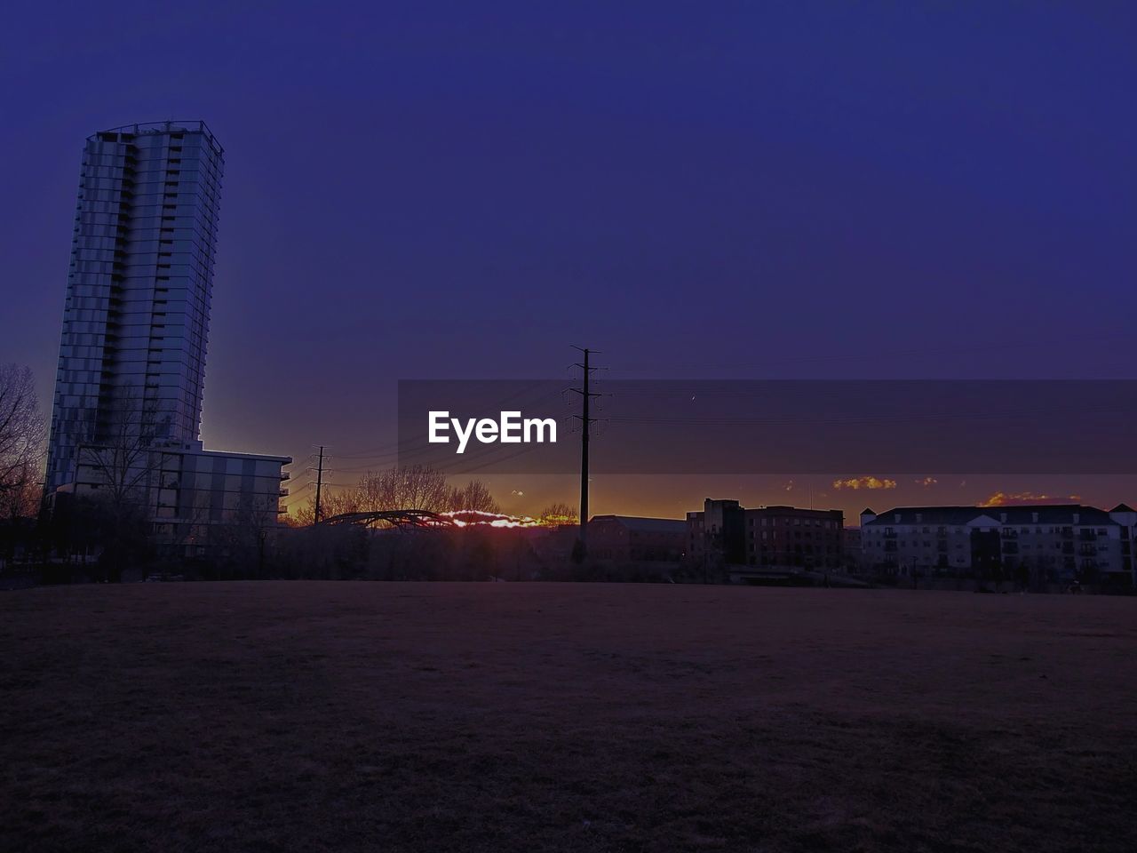 VIEW OF ILLUMINATED CITYSCAPE AGAINST SKY