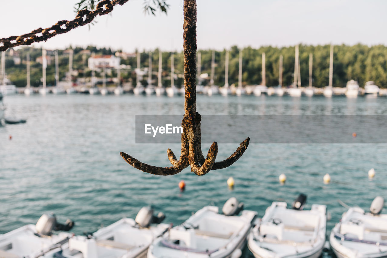 Rusty anchor with a harbour background