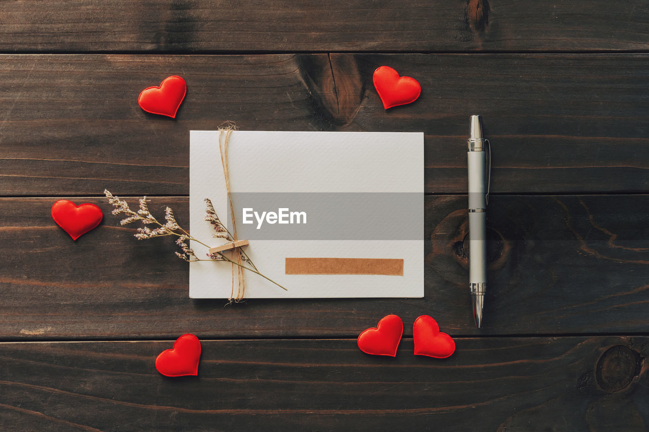 Valentine card with red heart on wooden background