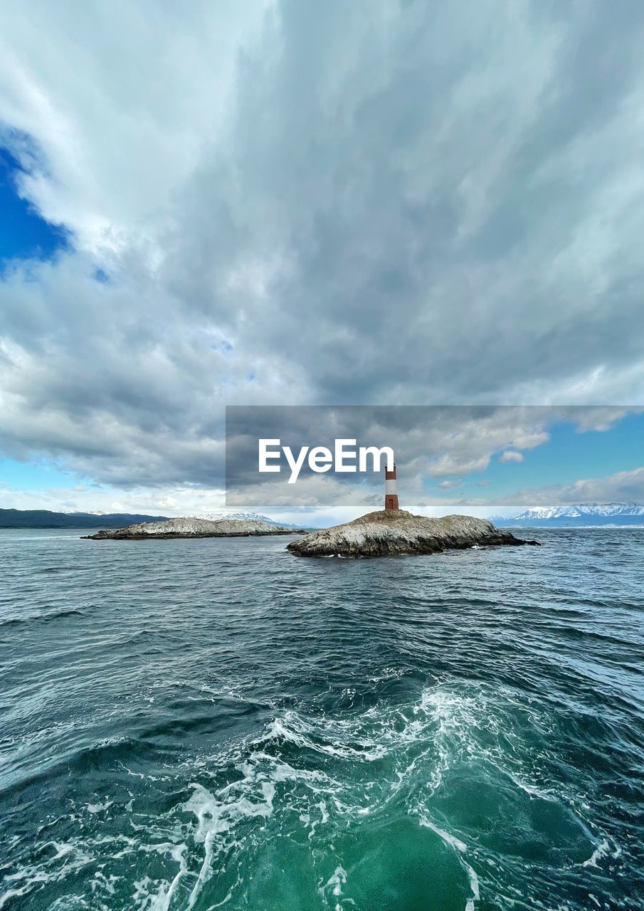 water, sea, ocean, sky, cloud, lighthouse, wind wave, wave, nature, travel, coast, beauty in nature, scenics - nature, horizon, environment, vehicle, shore, land, nautical vessel, travel destinations, holiday, outdoors, tower, one person, motion, vacation, transportation, trip, day, blue, landscape, sailing, beach, boating, tourism, adult, architecture, sports, tranquility, bay