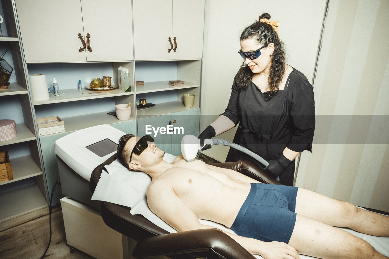 Beautician working with mask and protective screen for the virus covid