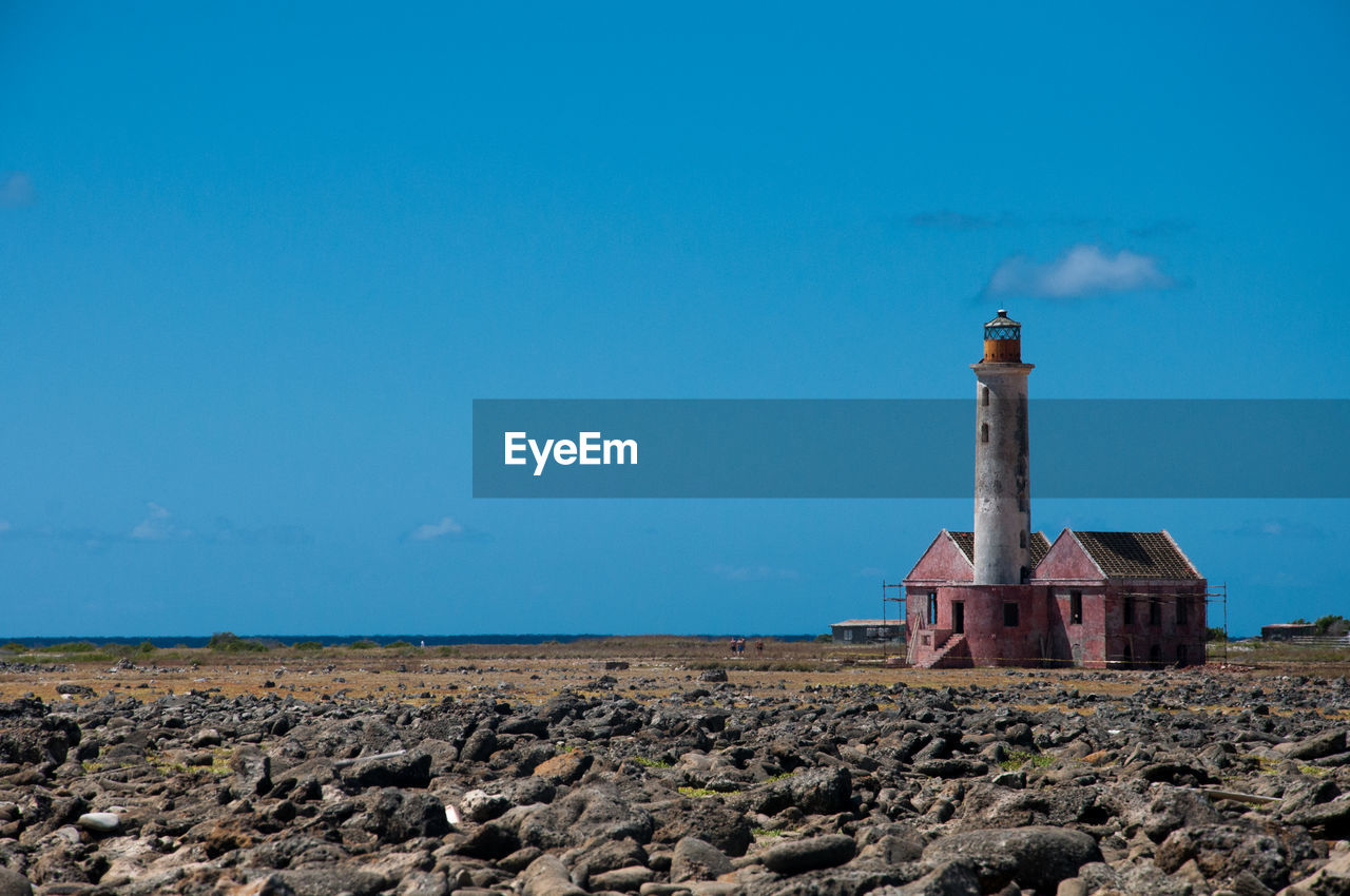 lighthouse by sea against sky