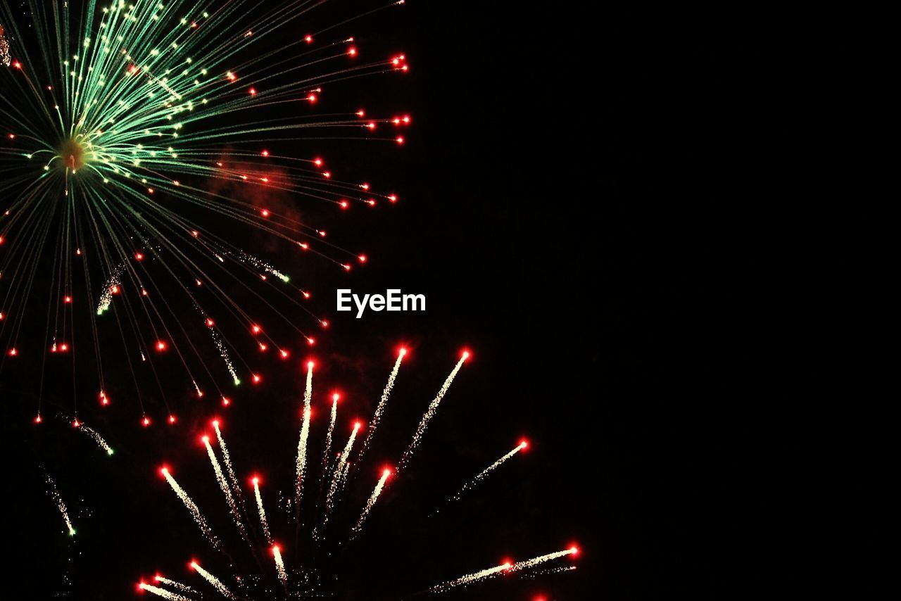 Low angle view of firework display at night