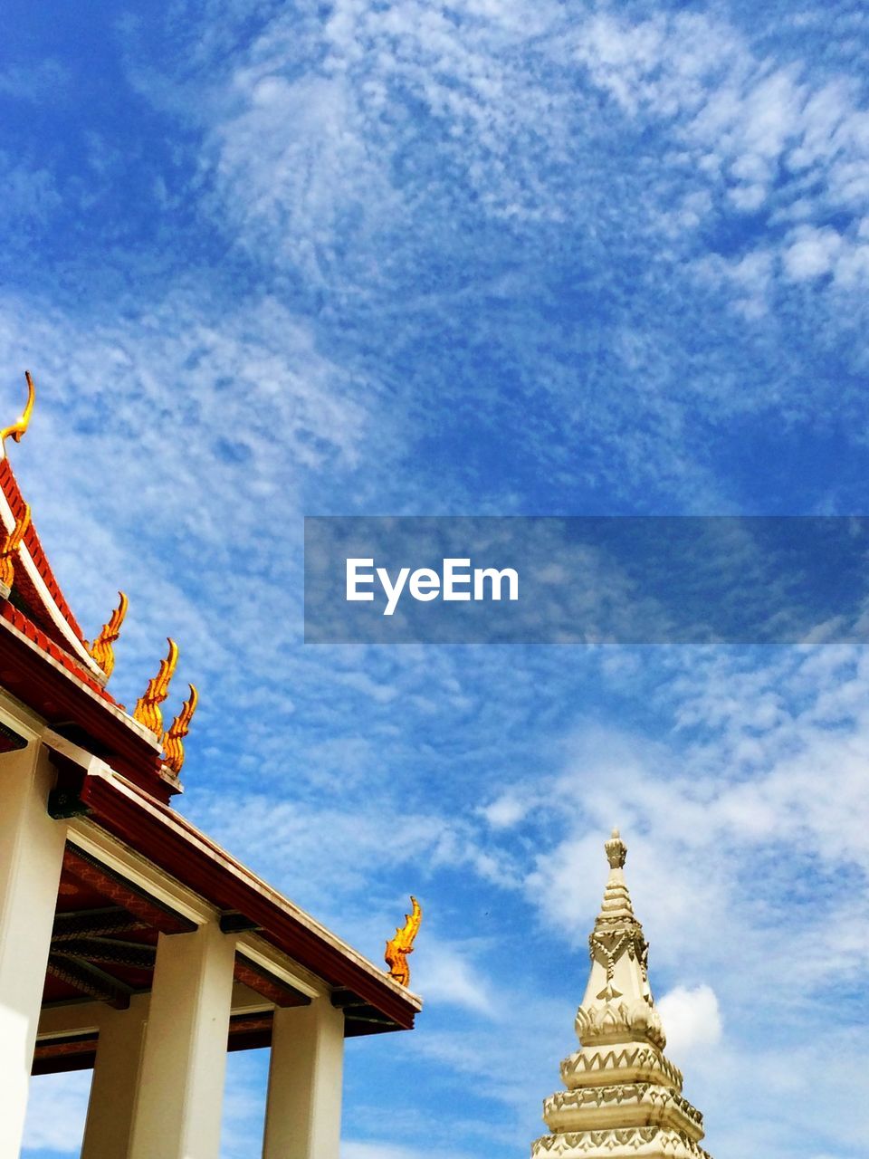 Low angle view of wat ratchanatdaram against cloudy sky