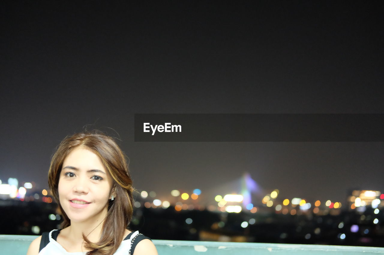 Portrait of smiling woman at night