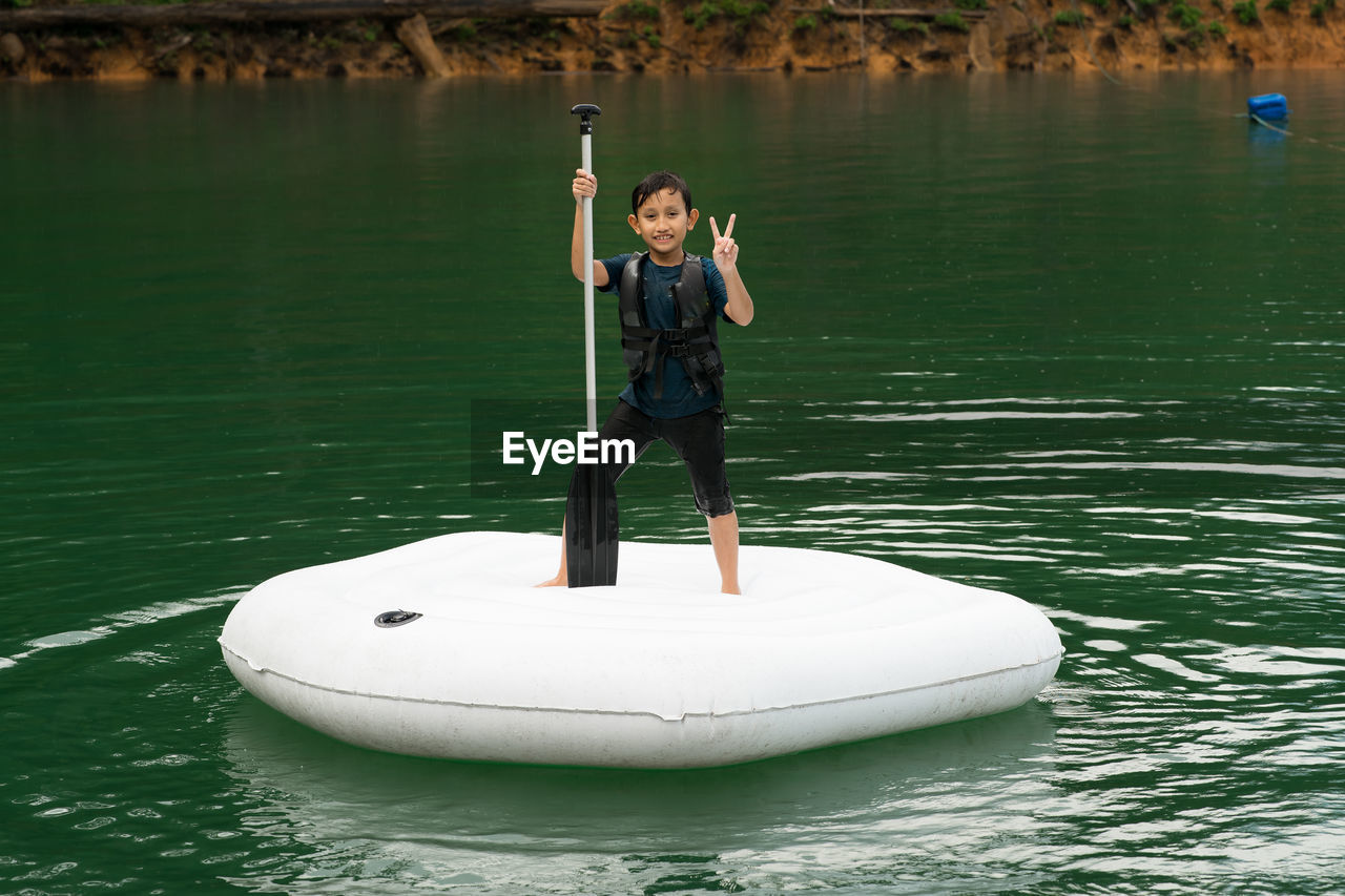 Man holding boat in lake