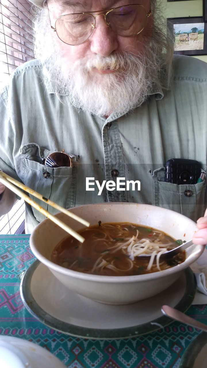 Close-up of man eating food at home