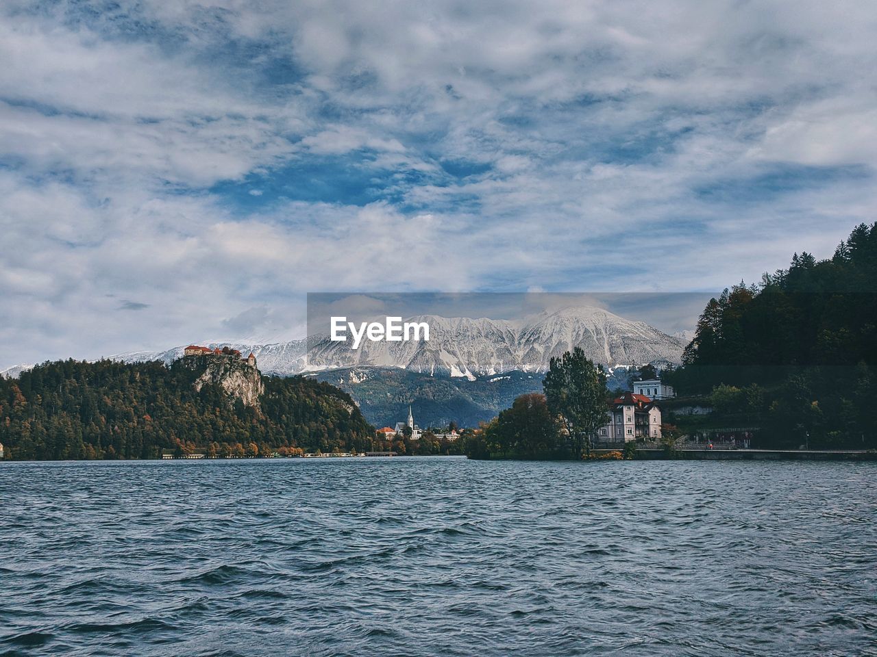 View of the snow-capped mountain peaks against the lake bled.