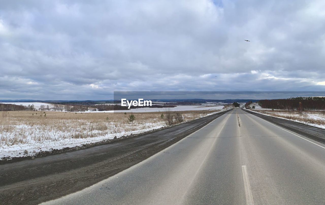 ROAD PASSING THROUGH LANDSCAPE AGAINST SKY